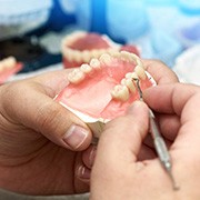 Lab technician’s hands making a set of dentures