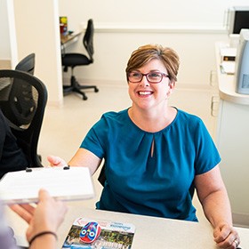 Smiling woman at dental reception desk