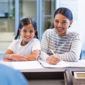 Mother and daughter checking in at reception desk