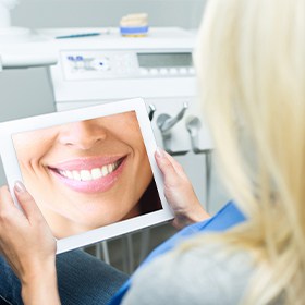 Woman looking at her smile design on tablet computer