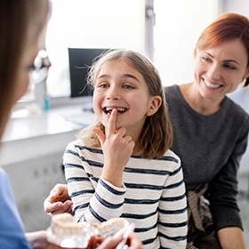 A girl and her mother at the dentist.