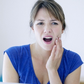 Woman in blue shirt with tooth pain
