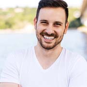 Man in white shirt smiling outside