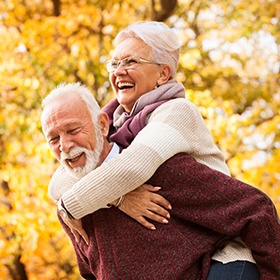 Senior couple with implant dentures in Goode, VA outside in fall