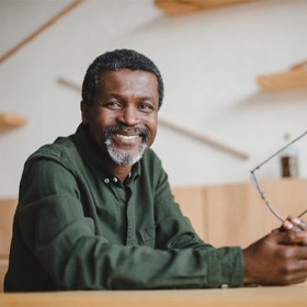 man smiling after getting dental implants in Goode