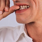 closeup of man biting fingernails  