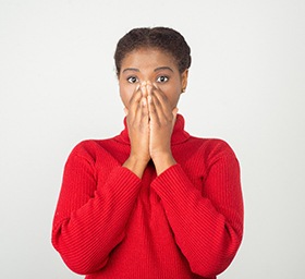 Woman covering mouth, in need of smile makeover in Goode