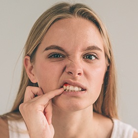 Woman pointing to her damaged gums