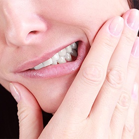 Closeup of grimacing patient holding jaw