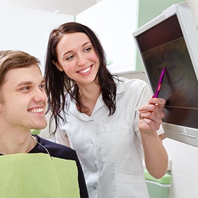 Dentist and patient looking at digital x-rays