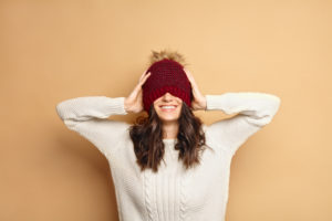 A woman wearing a hat smiling.