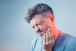 Man holding the side of his face in pain