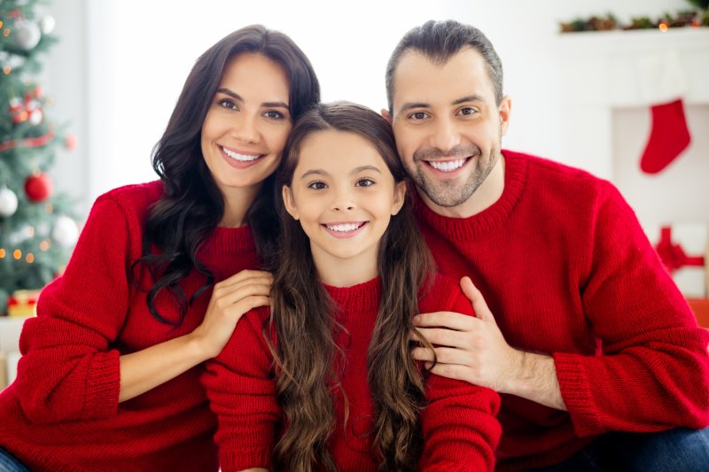 a family in red sweaters smiling