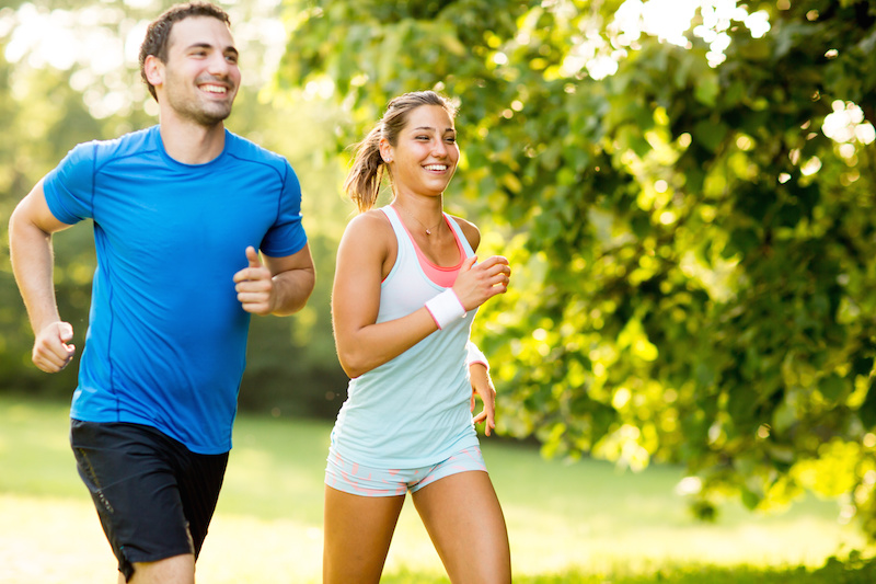 man and woman running in the park