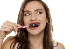 Woman using charcoal DIY whitening treatment